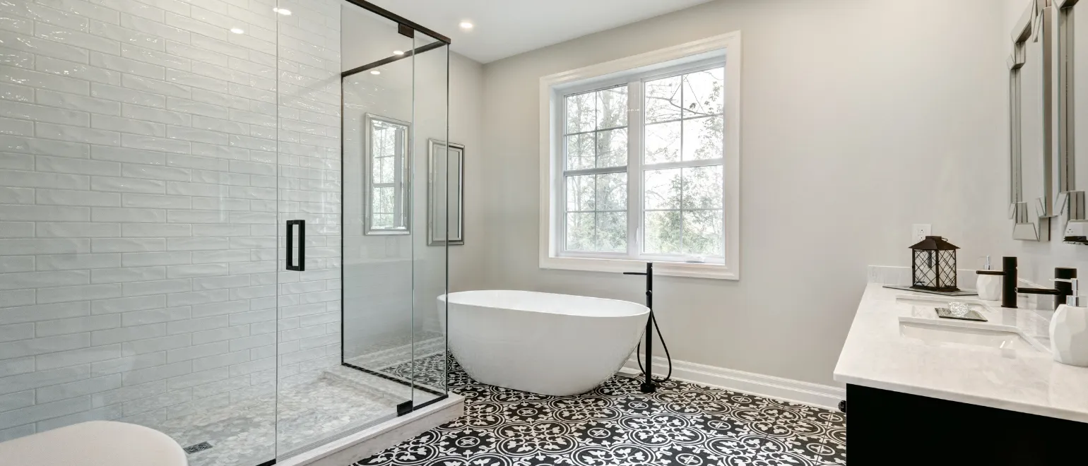 After bathroom remodeling project in Los Angeles with glass shower enclosure, freestanding bathtub, patterned tile flooring, modern vanity, and spa-style renovation finish